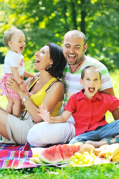 Jovem casal feliz com seus filhos se divertindo em um belo parque ao ar livre na natureza