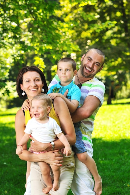 Jovem casal feliz com seus filhos se divertindo em um belo parque ao ar livre na natureza