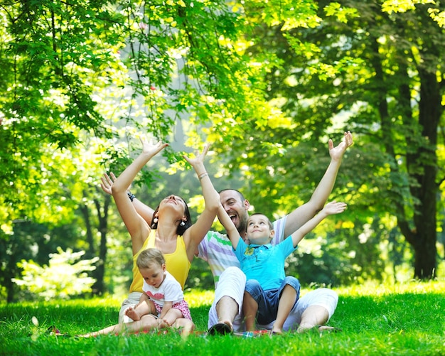 Jovem casal feliz com seus filhos se divertindo em um belo parque ao ar livre na natureza