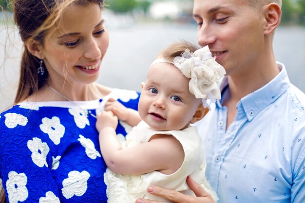 Jovem casal feliz com uma menina em pé na água menina de vestido azul, camisa de menino em estilo marinho