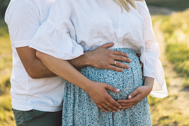 Jovem casal feliz e grávida ao ar livre