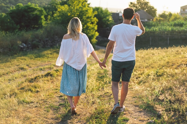 Jovem casal feliz e grávida ao ar livre