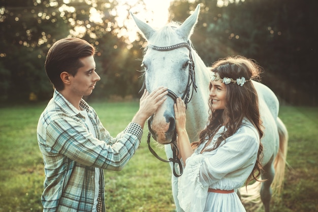 Jovem casal feliz e lindo cavalo