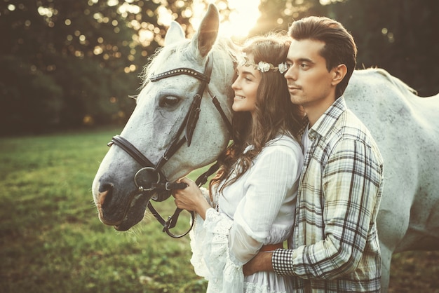 Jovem casal feliz e lindo cavalo