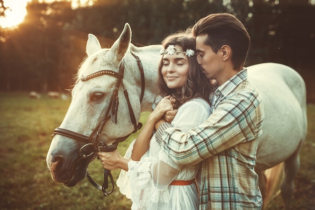 Jovem casal feliz e lindo cavalo