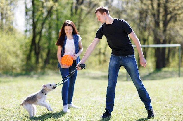 Jovem casal feliz e seu cachorro no parque