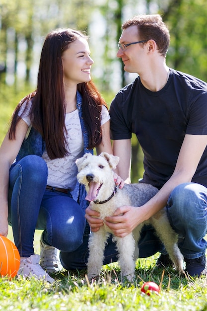 Jovem casal feliz e seu cachorro no parque