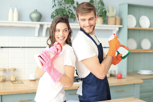 Jovem casal feliz está se divertindo ao fazer a limpeza em casa.