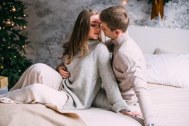 Jovem casal feliz ficando na cama em casa