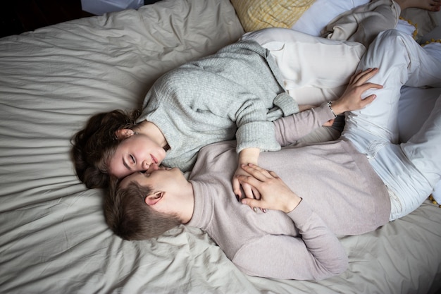 Jovem casal feliz ficando na cama em casa