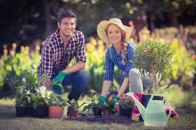 Jovem casal feliz, jardinando juntos