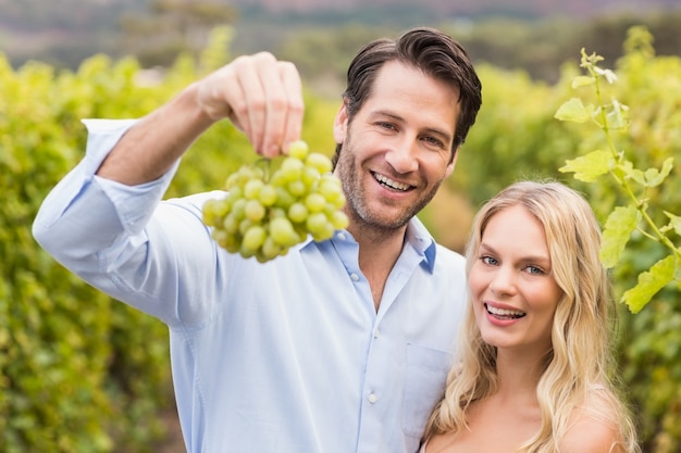 Jovem casal feliz olhando uvas