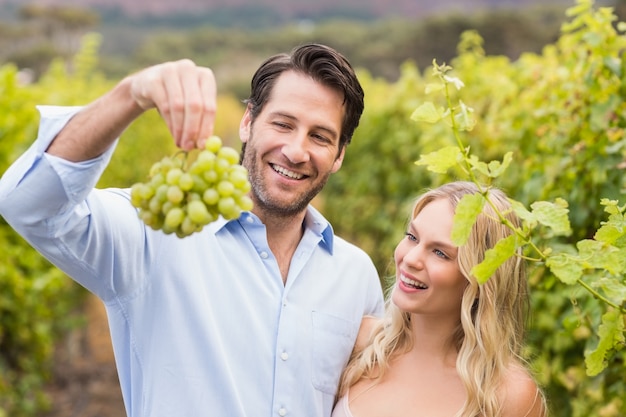 Jovem casal feliz olhando uvas