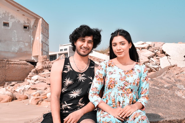 jovem casal feliz pose frontal na praia modelo paquistanês indiano