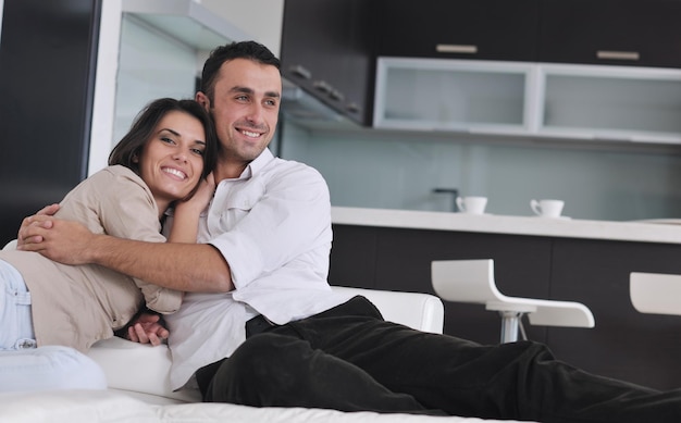 Jovem casal feliz relaxando na moderna sala de estar interna