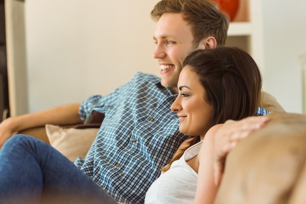 Jovem casal feliz relaxando no sofá