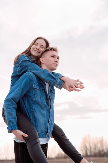 Jovem casal feliz se abraçando ao ar livre no parque se divertindo