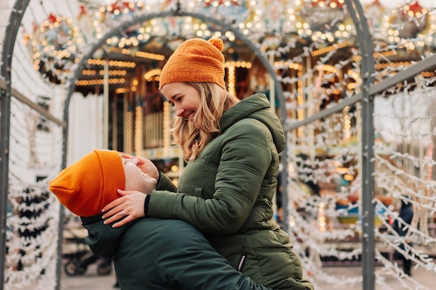 Jovem casal feliz se divertindo juntos em um mercado de Natal