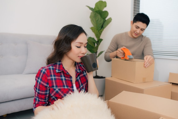 Jovem casal feliz se mudando para um novo apartamento com caixas de embalagem