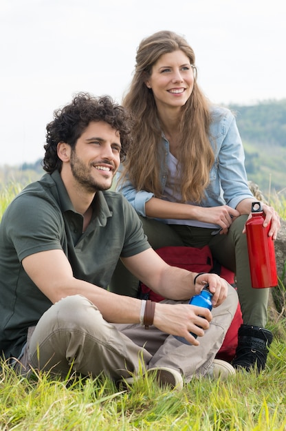 Foto jovem casal feliz sentado junto olhando o panorama