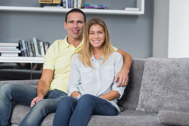 Jovem casal feliz sentado no sofá