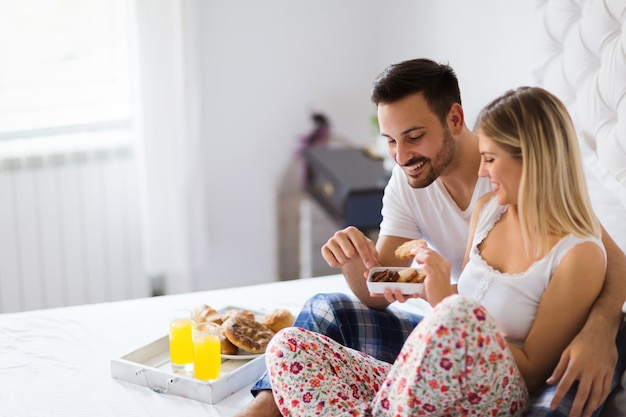 Jovem casal feliz tendo momentos românticos no quarto