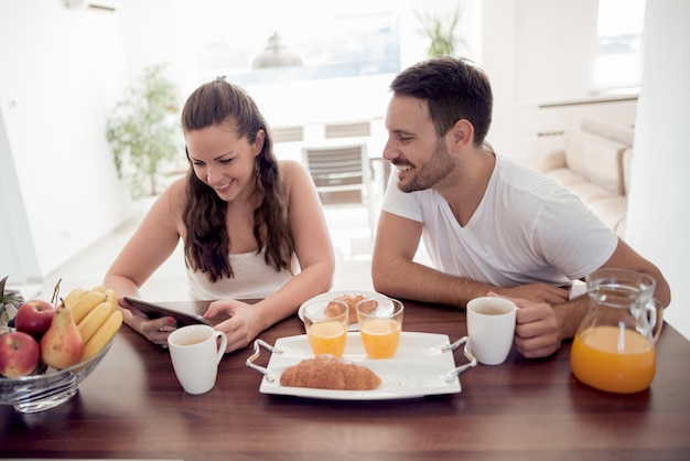 Jovem casal feliz tomando café da manhã juntos