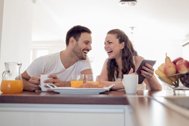 Jovem casal feliz tomando café da manhã juntos