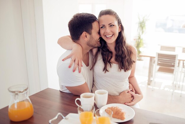 Jovem casal feliz tomando café da manhã juntos