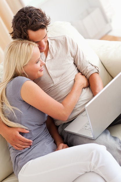 Jovem casal feliz usando um laptop