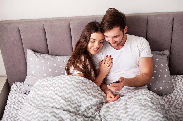 Jovem casal fofo juntos na cama