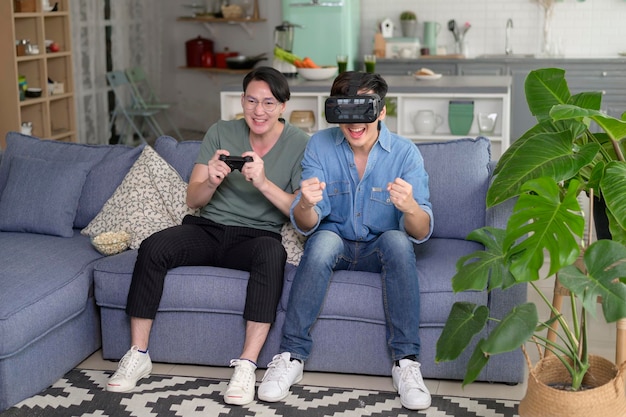 Jovem casal gay sorridente jogando videogame na sala de estar em casa LGBTQ e diversidade