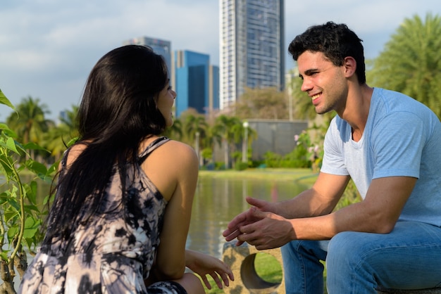 Jovem casal hispânico relaxando no parque juntos