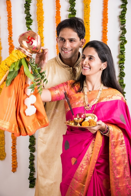 Jovem casal indiano inteligente realizando Gudi Padwa Puja em roupas tradicionais e pooja thali. É um ano novo hindu celebrado em toda a Índia