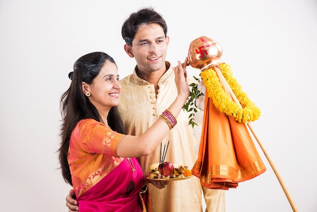Jovem casal indiano inteligente realizando Gudi Padwa Puja em roupas tradicionais e pooja thali. É um ano novo hindu celebrado em toda a Índia