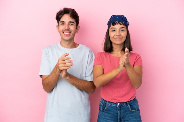 Jovem casal isolado em fundo rosa aplaudindo após apresentação em uma conferência