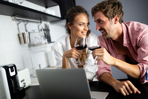 Jovem casal lindo e sexy cozinhando juntos e bebendo vinho