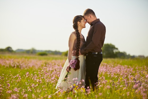 Jovem casal lindo em um campo com flores