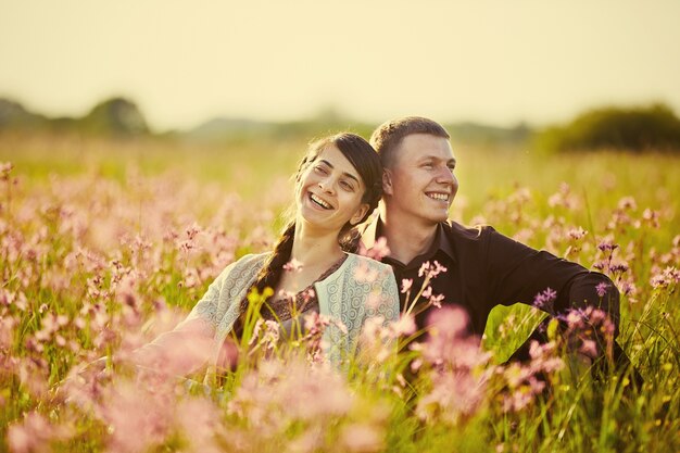 Jovem casal lindo em um campo com flores