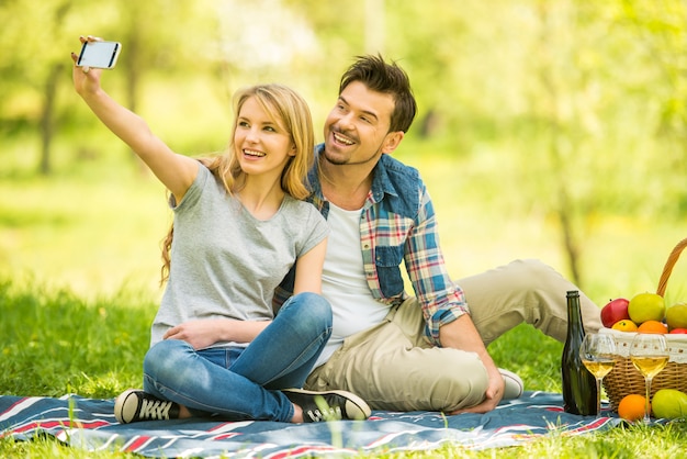 Jovem casal lindo fazer selfie na floresta.