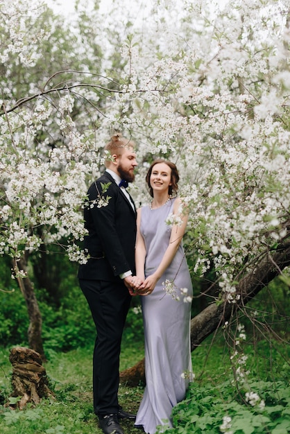 Jovem casal lindo no jardim no contexto de flores de cerejeira 1