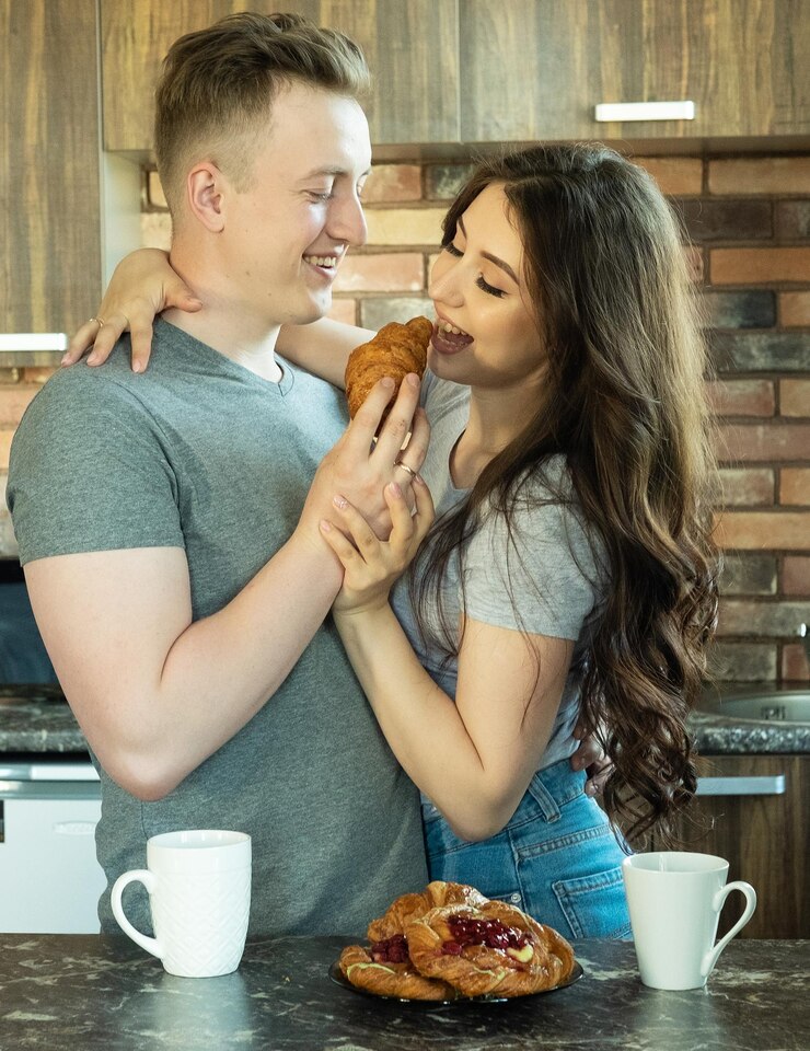 Foto jovem casal lindo toma café da manhã no início da manhã em casa abraço sorriso
