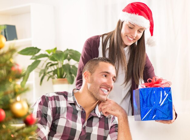 Jovem casal lindo trocando presentes de natal.