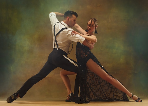 Jovem casal moderno e flexível dançando tango no estúdio. Retrato da moda de uma dança atraente