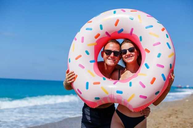 Jovem casal mulher e homem em óculos de sol no oceano Eles descansam e caminham juntos casal feliz de férias