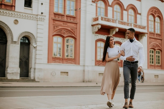 Jovem casal multiétnico andando na rua