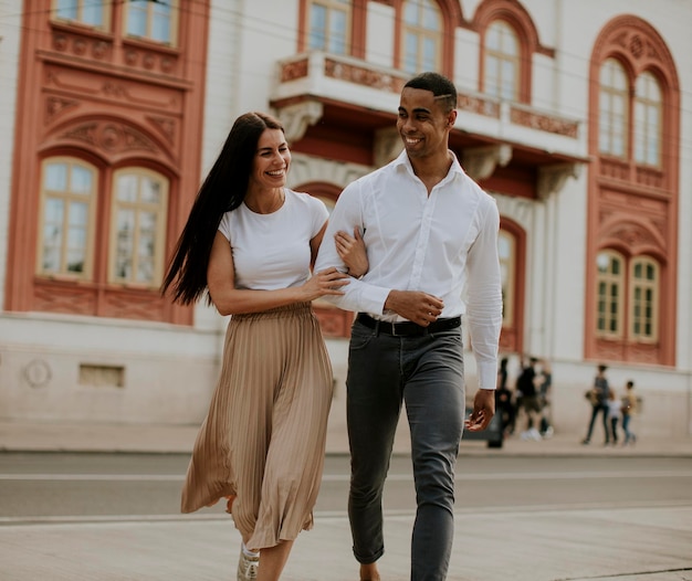 Jovem casal multiétnico andando na rua