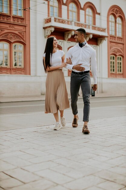 Jovem casal multiétnico andando na rua