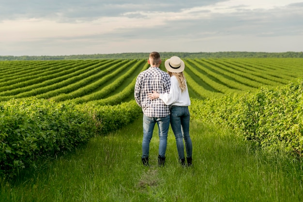 Jovem casal na fazenda, admirando a vista