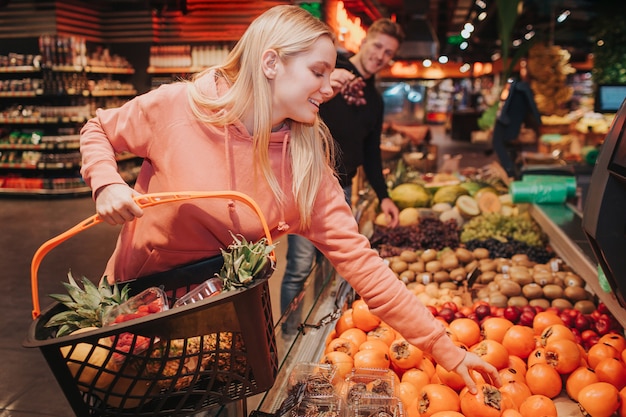 Jovem casal na mercearia levando frutas